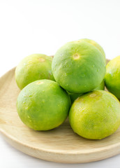 Limes on wooden dish on white background