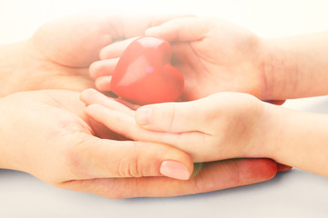 Heart in child and mother hands close up