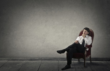 Young businessman sitting in a red chair