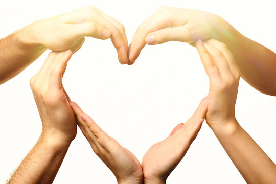 Heart formed by male and female hands on light background