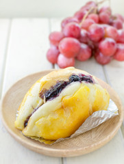 butter bread top up with blueberry sauce with grape background