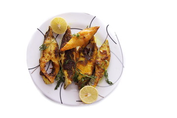 Slices of Pomfret fish fry served on white color plate over white background.