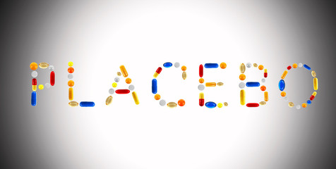The word Placebo made with pills on color background