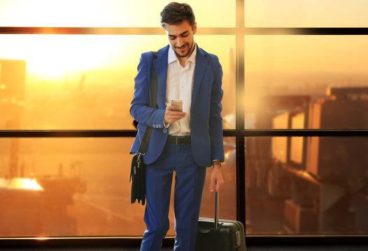 Business man with suitcase in hall of airport