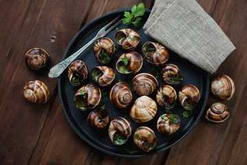 Bourgogne snails with garlic butter in a frying pan, top view