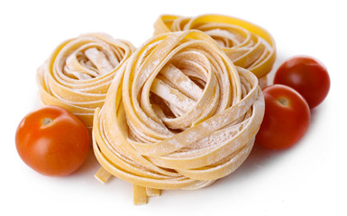 Pasta tagliatelle nests with cherry tomatoes isolated on white