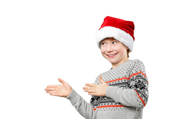 Portrait of a boy in christmas hat pointing at something with