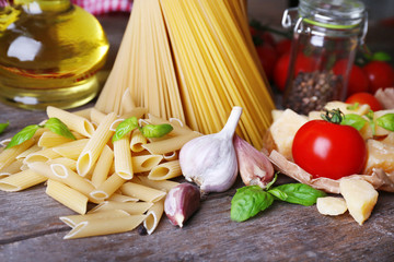Pasta with cherry tomatoes and other ingredients on wooden background