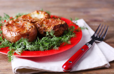 Baked potatoes with dill on pate on table close up