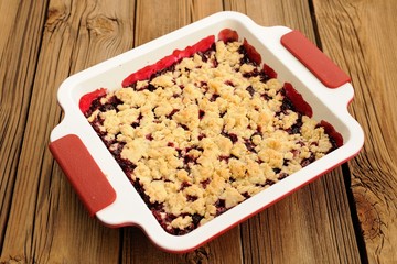 Tasty homemade cherry oat crumble in square white baking dish on