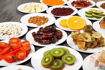 Different products on saucers on wooden table, closeup