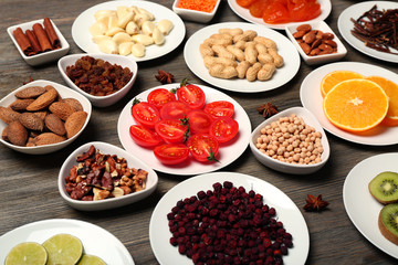 Different products on saucers on wooden table, closeup