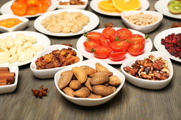 Different products on saucers on wooden table, closeup