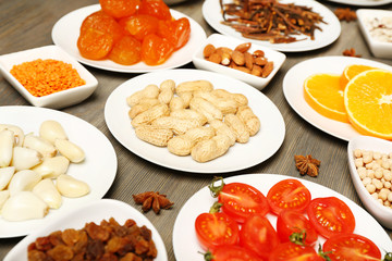 Different products on saucers on wooden table, closeup