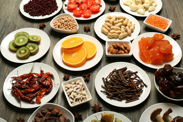 Different products on saucers on wooden table, closeup
