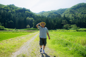 田舎を笑顔で散歩しているシニア