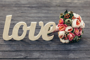 The word love with beautifull wedding bouquet on wooden backgrou - 87785203