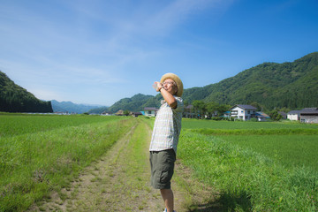 田舎で散歩しながら水補給するシニア