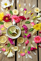 Cup of herbal tea with beautiful flowers, on wooden background