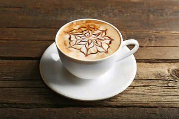 Cup of latte art coffee on wooden background
