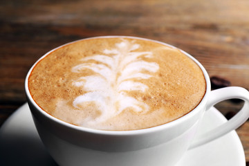 Cup of latte art coffee with grains, closeup