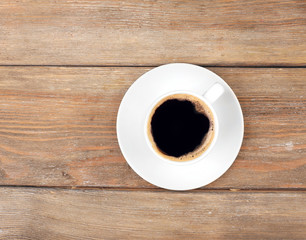 Cup of coffee on wooden table, top view