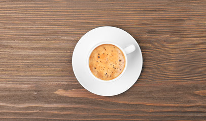 Cup of coffee on wooden table, top view