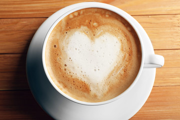 Cup of coffee latte art on wooden table, closeup