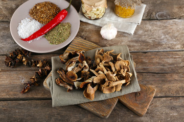 Dried mushrooms with spices on wooden background