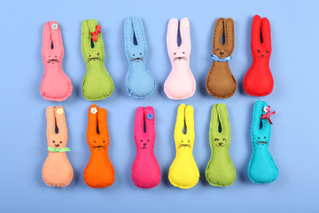 Handmade Easter rabbits on color table, top view