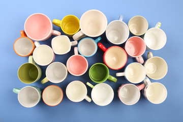 Group of colorful cups on color table, top view