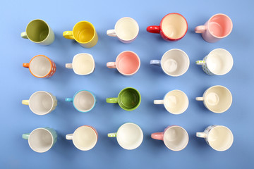 Group of colorful cups on color table, top view