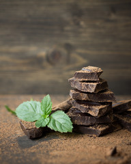 Dark chocolate with mint sprinkled with cocoa powder on a wooden surface