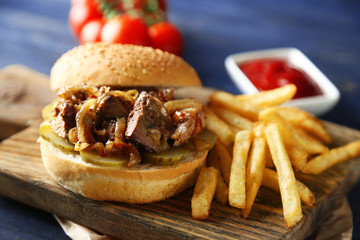 Tasty burger and french fries on wooden table background , close-up Unhealthy food concept