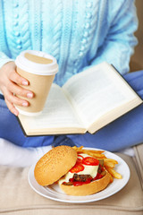 Woman with unhealthy fast food, close-up