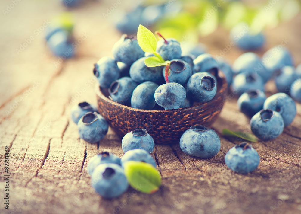 Poster Blueberry on wooden background. Ripe and juicy fresh picked blueberries closeup