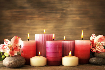 Fototapeta na wymiar Beautiful composition with candles and spa stones on wooden background