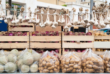 White onions hanging on the truck of a vegetables street peddler