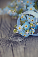 Forget-me-nots with a blue tape on a wooden table
