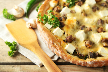 Cheese pie with mushrooms, herbs and sour creme, on wooden table background