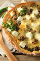 Cheese pie with mushrooms, herbs and sour creme, on wooden table background
