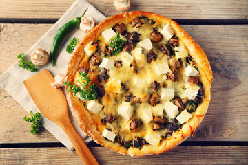 Cheese pie with mushrooms, herbs and sour creme, on wooden table background