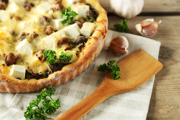 Cheese pie with mushrooms, herbs and sour creme, on wooden table background