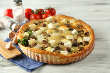 Cheese pie with mushrooms, herbs and sour creme, on wooden table background