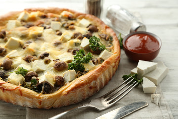 Cheese pie with mushrooms, herbs and sour creme, on wooden table background