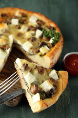 Cheese pie with mushrooms, herbs and sour creme, on color wooden table background