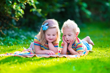 Two kids reading in summer garden