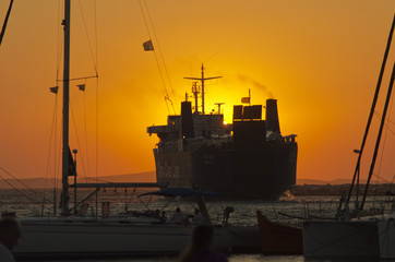 Fototapeta premium A cargo ship leaves Naxos at sunset_II