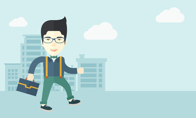 Young man walking through the city street with his briefcase.