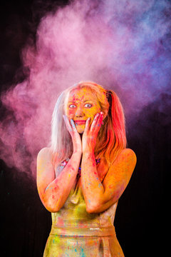 Beautiful young woman covered with colored powder